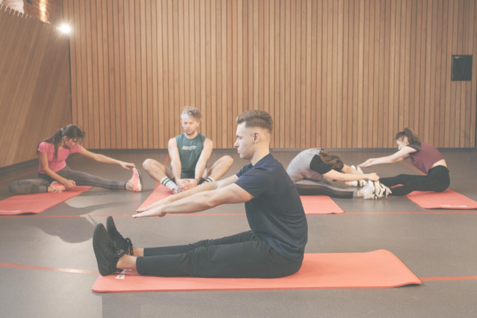 Participants in an online group gymnastics class performing corrective movement exercises